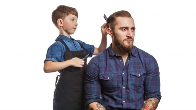 子供に髪を整えてもらっている男性